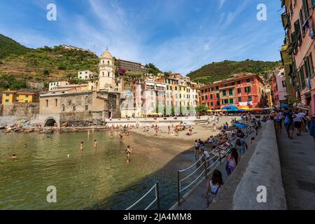 Der Sandstrand des alten Dorfes Vernazza ist an einem sonnigen Sommertag voller Touristen. Cinque Terre, Nationalpark in Ligurien, La Spezia, Italien. Stockfoto