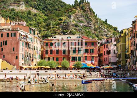 Der Sandstrand des alten Dorfes Vernazza ist an einem sonnigen Sommertag voller Touristen. Cinque Terre, Nationalpark in Ligurien, La Spezia, Italien. Stockfoto