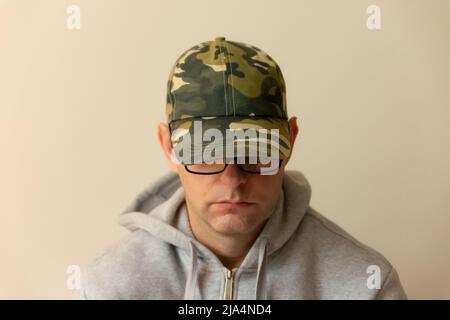 Trauriger Einzelmensch mit Brille und gesenktem Kopf Stockfoto