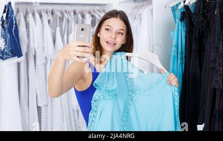 Frau, die sich für Kleid und Selfie entscheidet Stockfoto