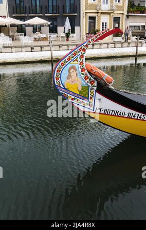 Reflexion und bunte Bogen von Moliceiros Boot an einem Kanal in Aveiro festgemacht Stockfoto