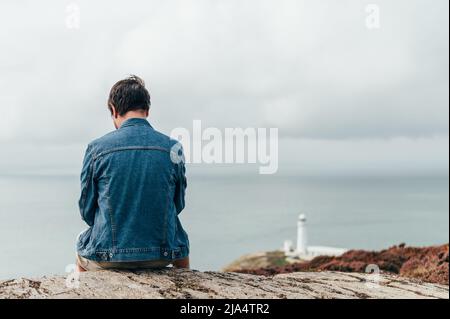 Der Mensch steht am Rand der Klippe auf dem irischen Meer Stockfoto