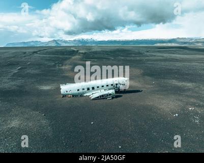 Luftaufnahme des alten abgestürzten Flugzeugs, das am Strand von Solheimasandur in der Nähe von Vik, Island, aufgegeben wurde. Stockfoto