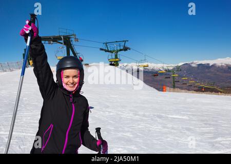 Frau mit Skiausrüstung und Skifahren in schnaufenden Bergen Stockfoto