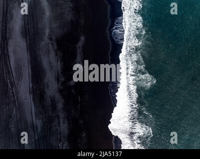 Schwarzer isländischer Sandstrand mit riesigen Wellen am Reynisfjara Vik. Stockfoto