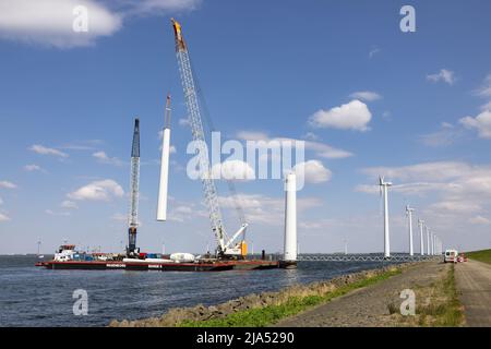 Lelystad, Niederlande - 22. April 2022: Kranschiff und Versorgungsschiff sind mit dem Abriss einer alten Offshore-Windkraftanlage beschäftigt Stockfoto