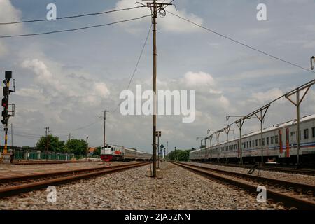 Lokomotive und Passangerzug hielten am Bahnhof in Java Island Indonesia Stockfoto