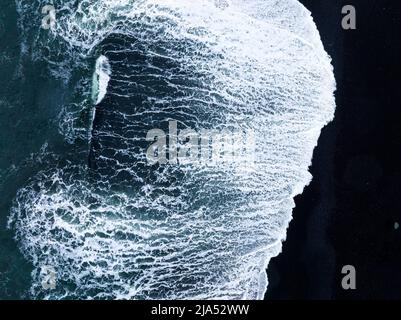 Schwarzer isländischer Sandstrand mit riesigen Wellen am Reynisfjara Vik. Stockfoto