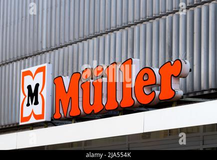 Müller-Logo auf einer Fassade. Müller ist in erster Linie ein Kosmetikgeschäft mit großer Drogerie- und Parfümerieabteilung mit Sitz in Ulm, Deutschland. Stockfoto
