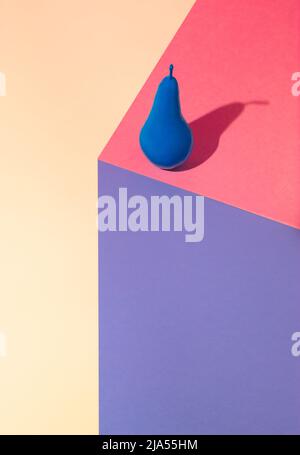 Trendige isometrische Zusammensetzung mit Birne auf geometrischem, farbenfrohem Hintergrund. 3D Blaue Birne auf Papierwürfel rendern. 2021 Minimale Sommeridee. Stockfoto