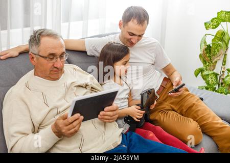 Großer glücklicher Familienvater mit mehreren Generationen, ältere Großeltern mit niedlichen kleinen Mädchen Enkelin zu Hause. Familie und Liebe Konzept Stockfoto