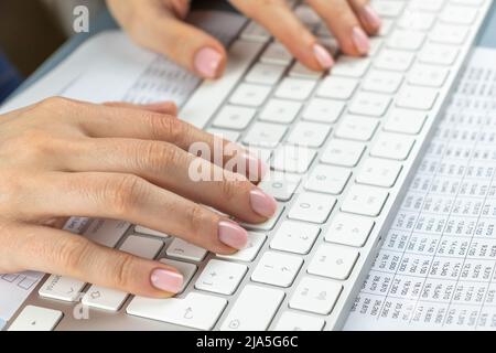 Frau, die auf der Tastatur tippt. Office-Buchhaltung, Zählen, Übersetzen, Copywriting, Zahlen Konzept. Nahaufnahme Hände hispanic Frau Stockfoto