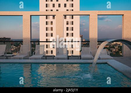 Die Morgensonne wirft Schatten auf die Säulen eines Dachpools in einer modernen Wohnung in der Stadt Guadalajara, Mexiko Stockfoto