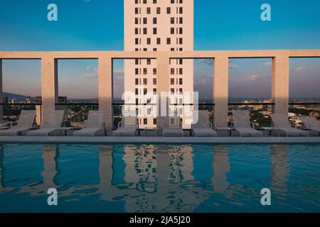 Die Morgensonne wirft Schatten auf die Säulen eines Dachpools in einer modernen Wohnung in der Stadt Guadalajara, Mexiko Stockfoto