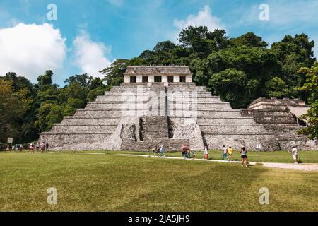 Touristen kommen am Tempel der Inschriften, der größten alten Maya-Pyramide in der archäologischen Zone Palenque im Bundesstaat Chiapas, Mexiko, vorbei Stockfoto