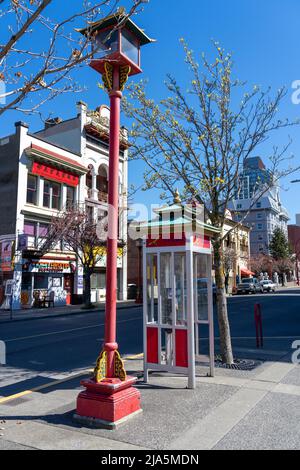 Victoria, BC, Kanada - 14 2021. April : Telefonzelle im chinesischen Stil und Straßenbeleuchtung in Victoria Chinatown. Stockfoto