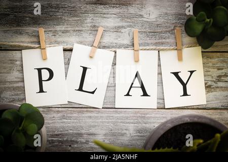 Eine Reihe von gedruckten Karten, die das WORTSPIEL auf einem alten Holzhintergrund schreiben. Stockfoto