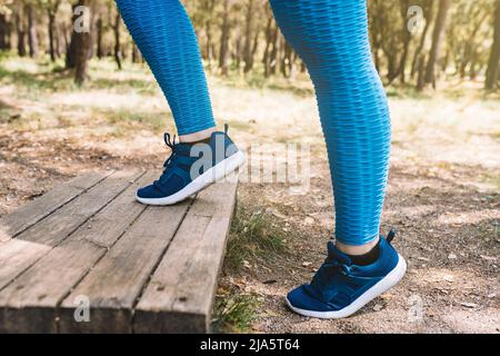 Nahaufnahme der Beine der jungen Sportlerin, dabei Aerobic-Übungen im Freien. Sportliche Frau springen. Gesundheit und Wellness-Lifestyle. Stockfoto