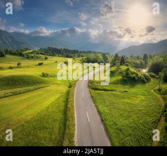 Luftaufnahme der Straße in grünen Wiesen und hils bei Sonnenuntergang im Sommer Stockfoto