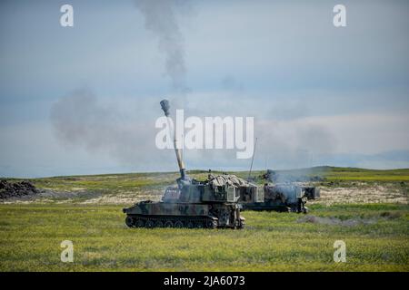 Die 1. der 148. Field Artillery Regiment der Idaho Army National Guard führten während ihrer jährlichen Ausbildung im Orchard Combat Training Center vom 12. Bis 27. Mai 2022 Live-Feuertraining mit dem M109A6 Paladin und über 80 hochexplosiven Runden durch. Das Training beinhaltete die erste Live-Feuerübung mit dem modernisierten M1156 Precision-Leitsatz der US-Armee, einem intelligenten GPS-Fuze-Aufsatz, der es dem Bataillon ermöglichte, seine vorhandenen 155mm Artilleriesullen in intelligente Waffen umzuwandeln und die Zielbahn zu verbessern. (USA Foto der Nationalgarde von Meister Sgt. Becky Vanshur) Stockfoto