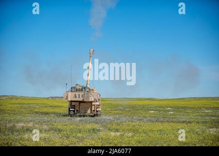 Die 1. der 148. Field Artillery Regiment der Idaho Army National Guard führten während ihrer jährlichen Ausbildung im Orchard Combat Training Center vom 12. Bis 27. Mai 2022 Live-Feuertraining mit dem M109A6 Paladin und über 80 hochexplosiven Runden durch. Das Training beinhaltete die erste Live-Feuerübung mit dem modernisierten M1156 Precision-Leitsatz der US-Armee, einem intelligenten GPS-Fuze-Aufsatz, der es dem Bataillon ermöglichte, seine vorhandenen 155mm Artilleriesullen in intelligente Waffen umzuwandeln und die Zielbahn zu verbessern. (USA Foto der Nationalgarde von Meister Sgt. Becky Vanshur) Stockfoto