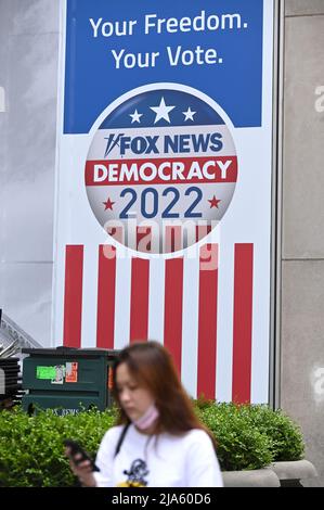 New York, USA. 27.. Mai 2022. Eine Frau geht an der Beschilderung „Democracy 2022“ vorbei, die auf der Außenfassade der News Corp. Fox News Studios 47. Street Facade, New York, NY, 27. Mai 2022, ausgestellt ist. (Foto von Anthony Behar/Sipa USA) Quelle: SIPA USA/Alamy Live News Stockfoto