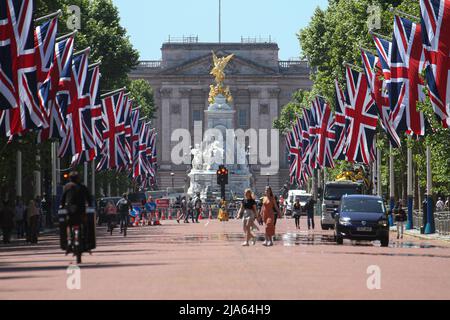 London, Großbritannien. 27.. Mai 2022. Die Menschen laufen über die Mall, die vor der Jubiläumsfeier von Union Jack-Fahnen geschmückt ist. Die 70-jährige Regierungszeit der Königin. Das Platin-Jubiläum umfasst Straßenfeste, das Londoner Trooping the Color, den Service of Thanksgiving, Konzerte und Festveranstaltungen, die über einen Zeitraum von vier Tagen gefeiert werden. Kredit: SOPA Images Limited/Alamy Live Nachrichten Stockfoto