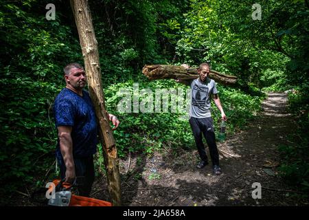 Lysytschansk, Ukraine. 26.. Mai 2022. Männer nach dem Holzhacken gesehen. Während russische Truppen die Offensive aus verschiedenen Richtungen starten und hoffen, ukrainische Vorräte und Verstärkungen aus dem Donbass-Gebiet abzuschneiden, wird die Stadt Lysytschansk, die mit Severodoonetsk verbunden ist, schwer bombardiert und die Menschen entschieden sich, unter schweren Beschuss unter der Erde zu leben. Kredit: SOPA Images Limited/Alamy Live Nachrichten Stockfoto