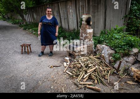 Lysytschansk, Ukraine. 26.. Mai 2022. Eine Frau, die neben einem Herd gesehen wird. Während russische Truppen die Offensive aus verschiedenen Richtungen starten und hoffen, ukrainische Vorräte und Verstärkungen aus dem Donbass-Gebiet abzuschneiden, wird die Stadt Lysytschansk, die mit Severodoonetsk verbunden ist, schwer bombardiert und die Menschen entschieden sich, unter schweren Beschuss unter der Erde zu leben. Kredit: SOPA Images Limited/Alamy Live Nachrichten Stockfoto