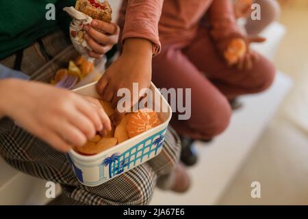 Gruppe von Klassenkameraden, die während der Schulpause einen Obstsnack essen. Stockfoto