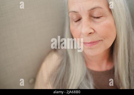 Nahaufnahme einer älteren Frau mit geschlossenen Augen. Stockfoto