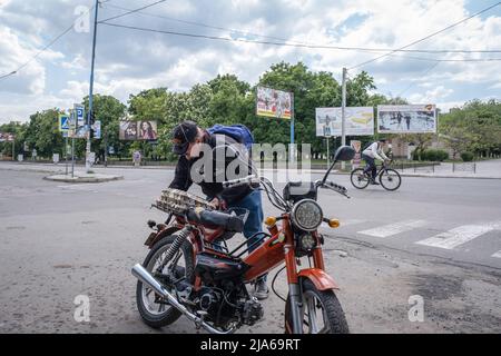 Bakhmut, Ukraine. 24.. Mai 2022. Ein Mann legt die Eier, die er gekauft hat, auf sein Motorrad in Bakhmut, Donbas. Da Bakhmut als Schlüsselstadt der ukrainischen Streitkräfte bei der Verteidigung der Donezker Region steht, wird die Stadt von russischen Truppen angegriffen. Die russische Invasion der Ukraine begann am 24. Februar, dem Krieg, der zahlreiche Zivilisten und Soldaten getötet hat. (Foto von Alex Chan Tsz Yuk/SOPA Images/Sipa USA) Quelle: SIPA USA/Alamy Live News Stockfoto