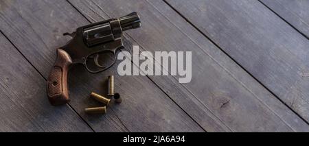 Revolver mit Kugeln auf dem Holztisch. Stockfoto