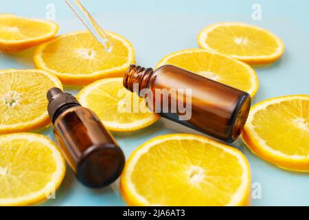 Braune Glasflasche mit einer Pipette Gesichtsserum mit Vitamin C. ätherisches Öl und Orangenscheiben. Gesundheits- und Schönheitskonzept. Organische Naturkosmetik. Stockfoto