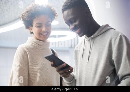 Zugeschnittenes Bild von ein paar Studenten mit einem Smartphone . Stockfoto
