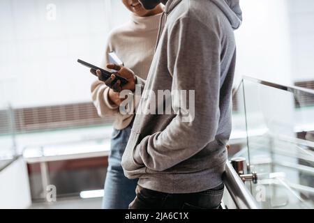 Zugeschnittenes Bild von ein paar Studenten mit einem Smartphone . Stockfoto