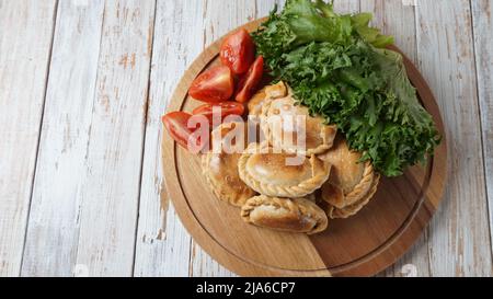 Lateinamerikanische gebratene Empanadas mit Tomatensauce. Argentinische Empanada ist ein Gebäck Umsatz mit einer Vielzahl von herzhaften Zutaten gefüllt und gebacken oder f Stockfoto