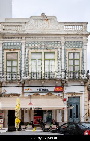 OLHAO, PORTUGAL - 13.. FEBRUAR 2022: Typische Architektur der Algarve rustikale Gebäude mit komplizierten Designs von Verkleidungsbrettungen, und kleine Unternehmen mögen Stockfoto