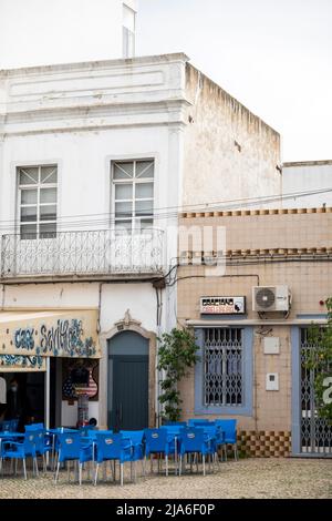 OLHAO, PORTUGAL - 13.. FEBRUAR 2022: Typische Architektur der Algarve rustikale Gebäude mit komplizierten Designs von Verkleidungsbrettungen, und kleine Unternehmen mögen Stockfoto