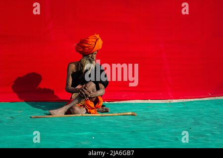 Während des Kumbh Mela Festivals sitzt ein Sadhu auf dem Boden. Alle zwölf Jahre beginnen Millionen von hinduistischen Anhängern eine massive Pilgerfahrt zu den heiligsten indischen Festen: Dem Kumbha Mela, der in Prayagraj stattfindet, einem Ort, der als besonders vielversprechend gilt, weil er sich am Zusammenfluss des Ganges, Yamuna und des mythischen Samswati befindet. Es wird geschätzt, dass im Jahr 2019 120 Millionen Menschen im Laufe von eineinhalb Monaten an der heiligen Einfriedung teilnahmen. Diese Zahlen entsprechen der Gesamtbevölkerung Japans und sind 40-mal so viele Pilger, die Mekka in der jährlichen Prozession besuchen Stockfoto