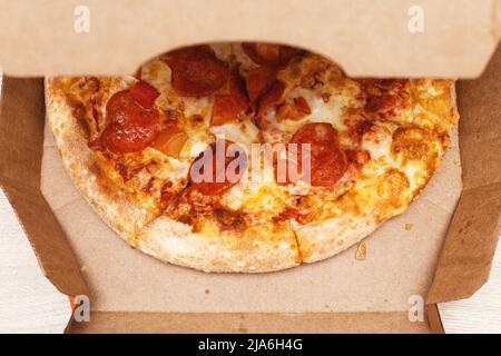 Eine Pizza in Pappkarton. Fast Food Delivery Konzept Stockfoto