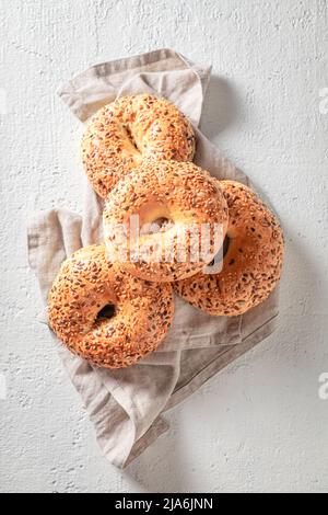 Einige goldene und heiße Bagels auf Leinentuch. Frisch gebackene süße Bagels zum Frühstück. Stockfoto