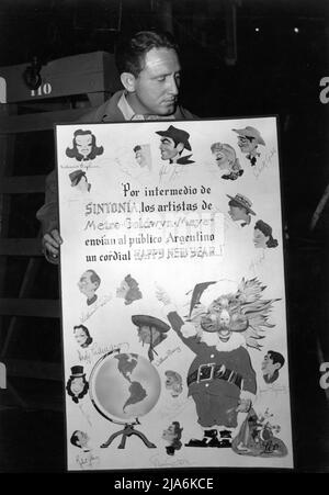 SPENCER TRACY am Set offen während einer Pause in der Dreharbeiten von FRAU DES JAHRES Posen mit großen Weihnachten / Neujahrskarte für 1941 / 1942 mit Jacques Kapralik-Karikaturen, die von den Top-MGM-Stars signiert wurden Die prominente argentinische Publikation Sintonia an die argentinische Öffentlichkeit für Metro Goldwyn Mayer Stockfoto