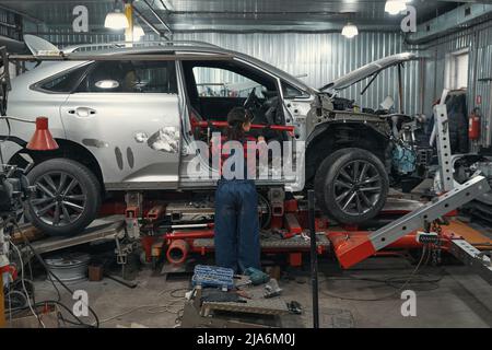 Weibliche Auto Mechaniker Reparatur Fahrzeug in der Garage Stockfoto