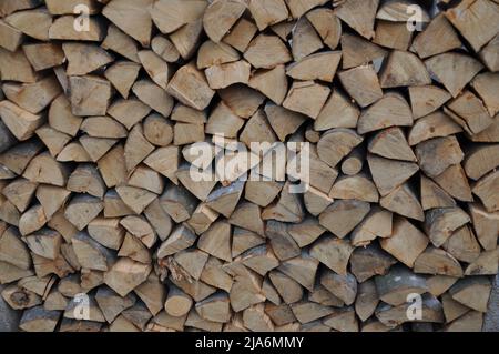 Ein Holzstapel, der für den kalten Winter vorbereitet ist. Kroatische Landschaft. Brennholz gestapelt Brennholz in verschiedenen Größen.trockenes, gehacktes Brennholz in einem Pil gestapelt Stockfoto