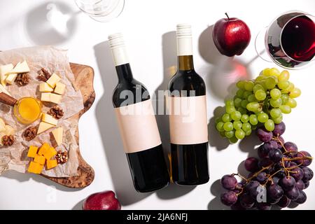 Blick von oben auf Weinflaschen mit Vorspeisen Stockfoto