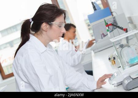 Schöne Wissenschaftlerin in ihrem Labor, die chemische Experimente durchführt Stockfoto