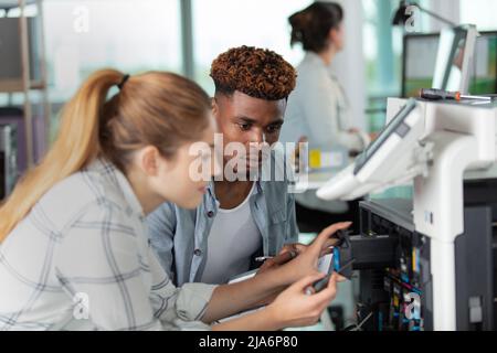 Frau und Mann arbeiten am Drucker Stockfoto