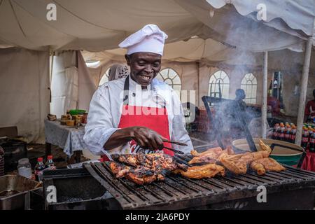 Nairobi, Kenia. 27.. Mai 2022. Während der FIFA-Weltmeisterschaft in Nairobi grillt ein Koch Hühnchen zum Verkauf. Die Trophäe der FIFA-Weltmeisterschaft landete in Kenia für eine zweitägige Tour, bei der die Öffentlichkeit vor der diesjährigen Weltmeisterschaft in Katar angesehen werden konnte. (Bild: © Donwilson Odhiambo/SOPA Images via ZUMA Press Wire) Stockfoto