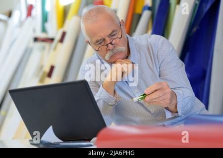 Älterer Mann mit Laptop und usb Stockfoto